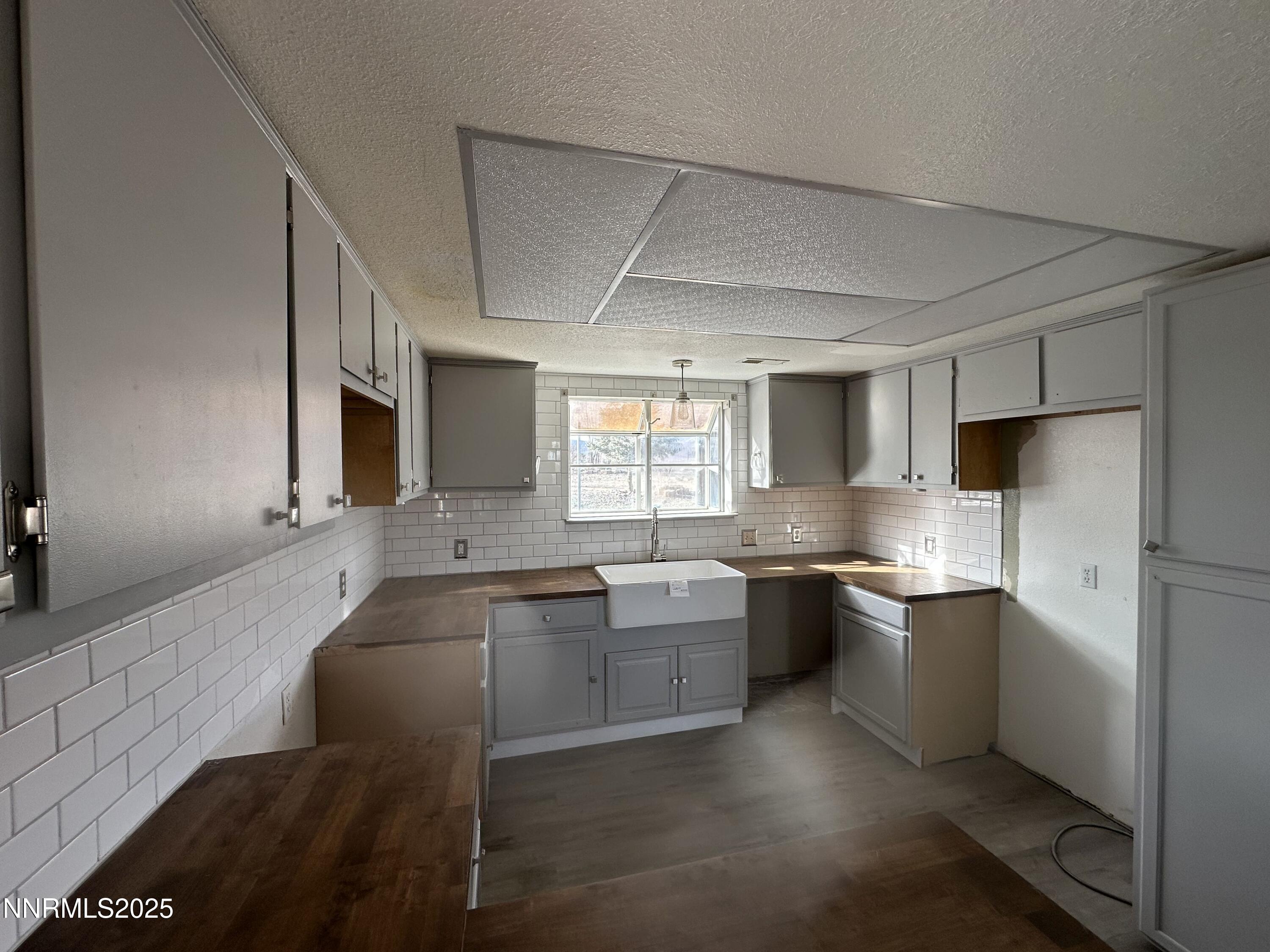 7710 Cheyenne Trail Stagecoach, NV 89429 - Photo 6 of 14 a large kitchen with kitchen island granite countertop a sink and white cabinets