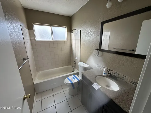 a bathroom with a sink a toilet a mirror and bathtub