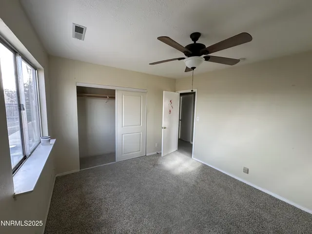 a view of a livingroom with a ceiling fan and window