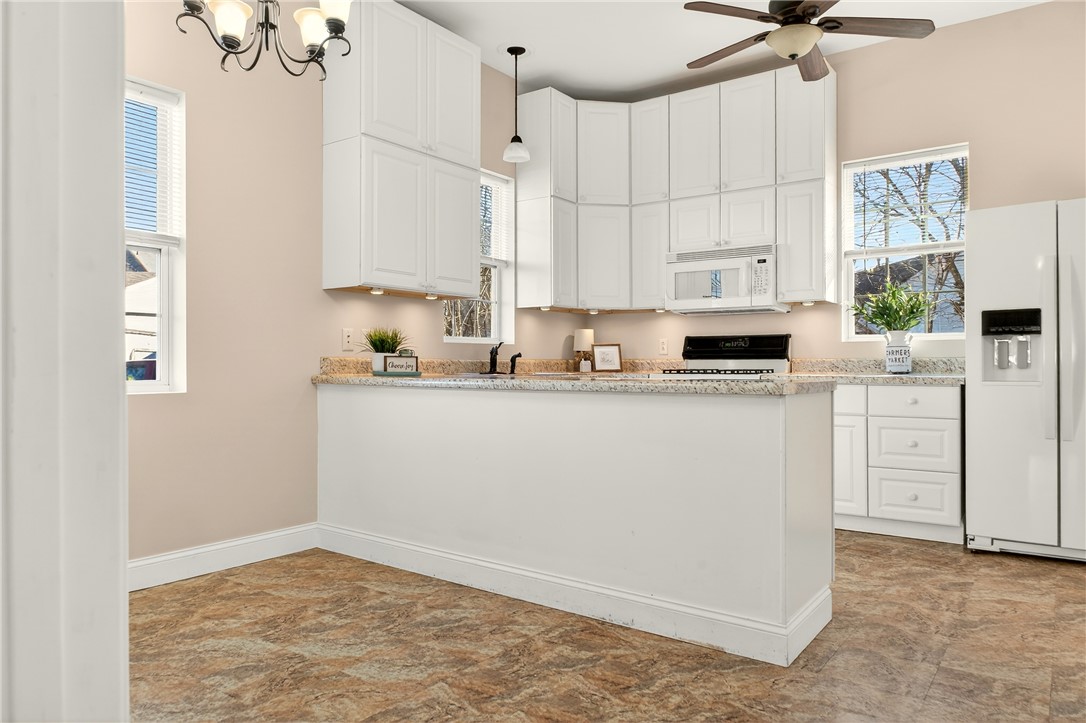 107 Riverside Drive Piqua, OH 45356 - Photo 11 of 69 This bright kitchen features ample cabinetry, generous counter space, and modern appliances for effortless living.