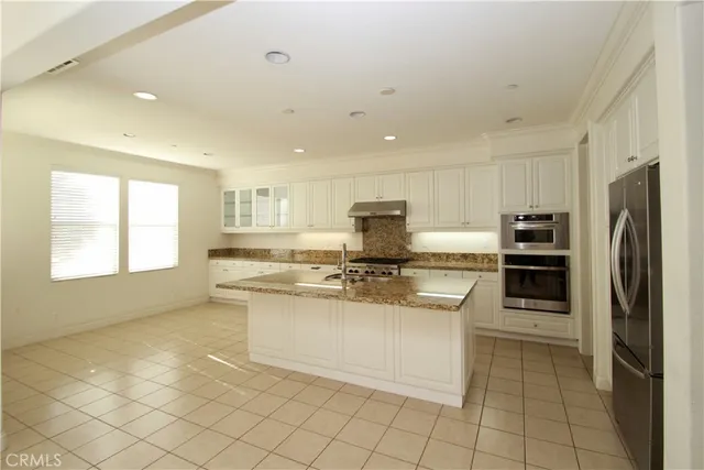 a kitchen with granite countertop white cabinets and stainless steel appliances