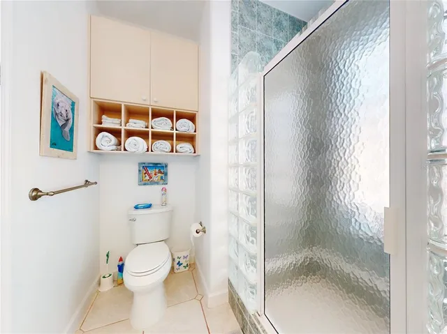 a white toilet sitting next to a shower