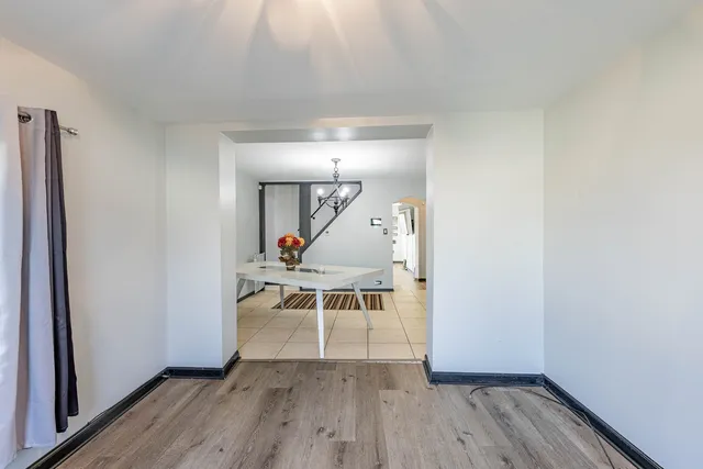 a view of a livingroom with wooden floor and a staircase