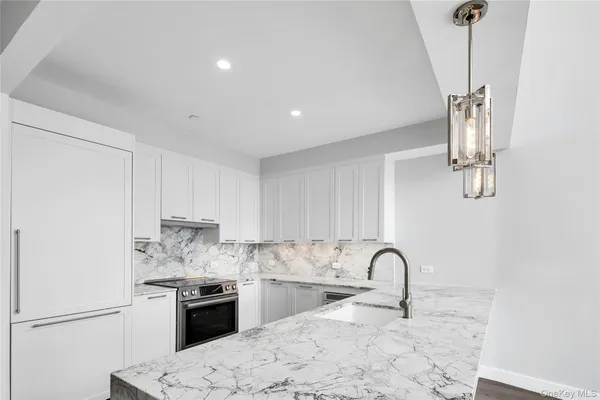 a kitchen with stainless steel appliances granite countertop a sink a stove top oven a counter space and cabinets