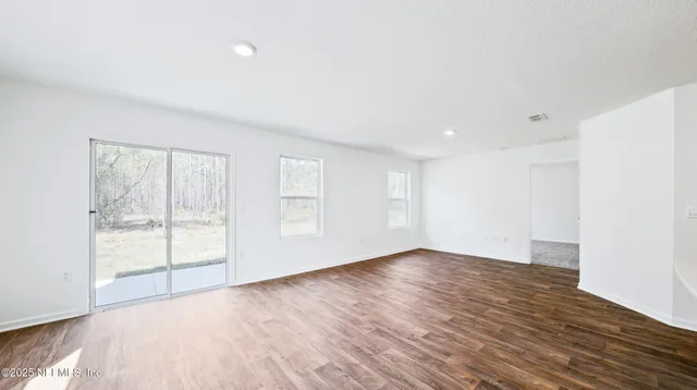 a view of a small space with wooden floor and a window