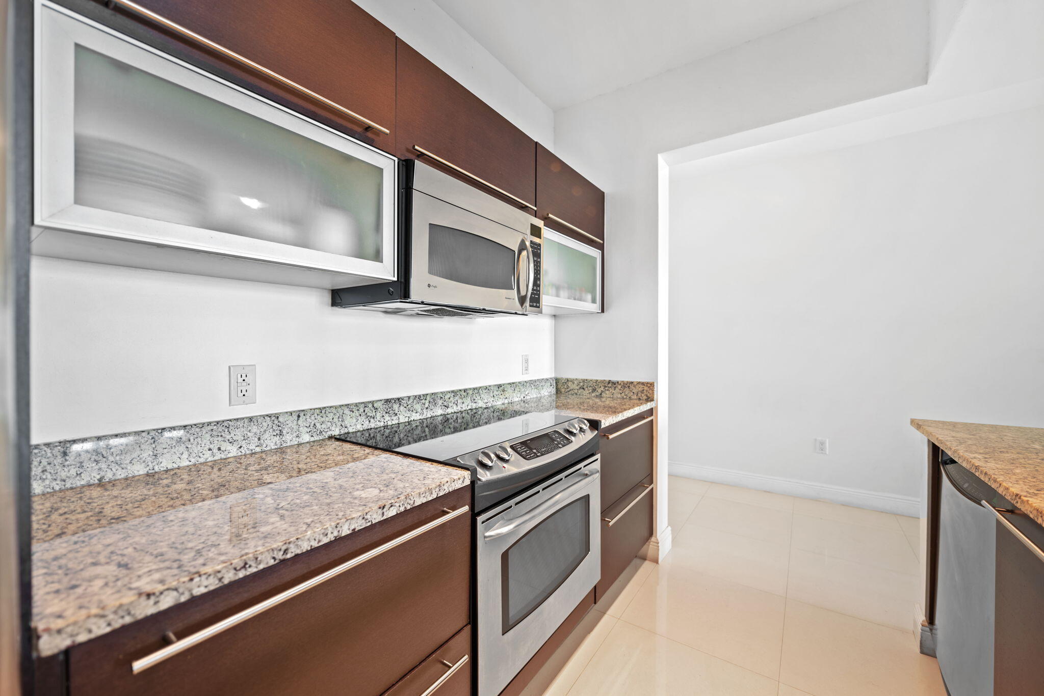 951 Brickell Avenue, Unit 400 Miami, FL 33131 - Photo 12 of 40 a kitchen with granite countertop a stove and a microwave