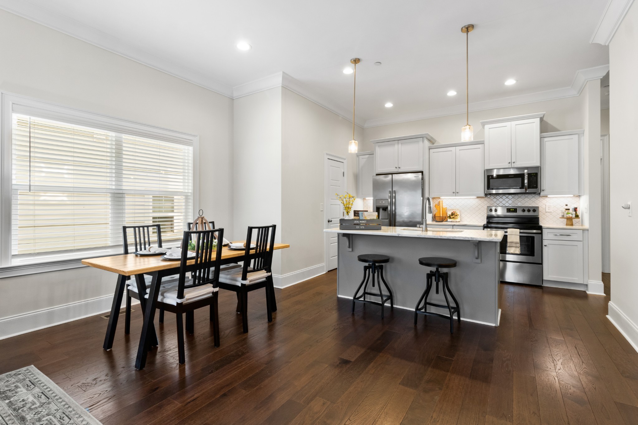 725 Centre Street Pleasant View, TN 37146 - Photo 12 of 44 a kitchen with stainless steel appliances granite countertop a stove a refrigerator a kitchen island a dining table and chairs with wooden floor