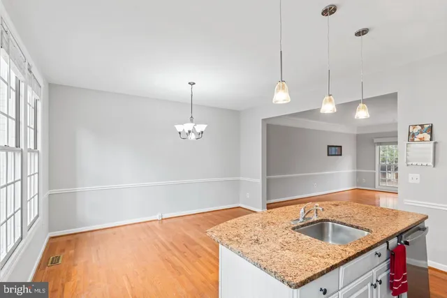 a bathroom with a granite countertop sink and a large mirror