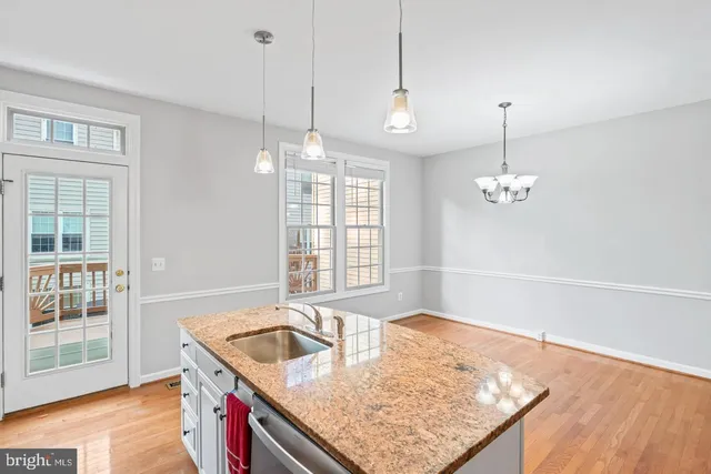 a kitchen with stainless steel appliances granite countertop a sink a oven a counter space and a window