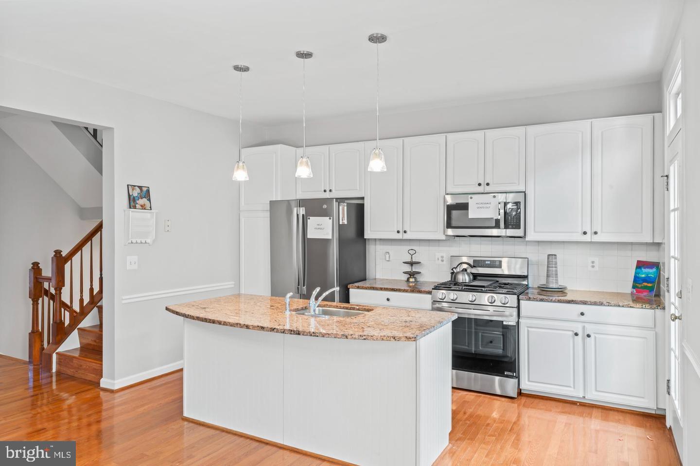 19893 Upland Terrace Ashburn, VA 20147 - Photo 17 of 29 a kitchen with stainless steel appliances kitchen island wooden cabinets a stove a sink and a refrigerator