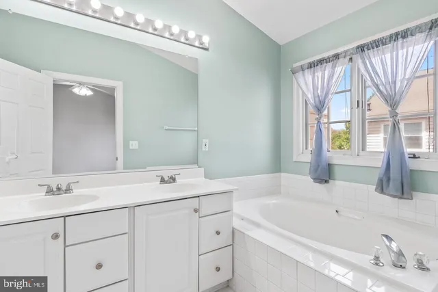 a bathroom with a sink a large mirror and a bathtub
