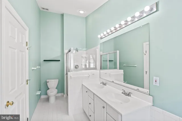 a spacious bathroom with a double vanity sink mirror and toilet