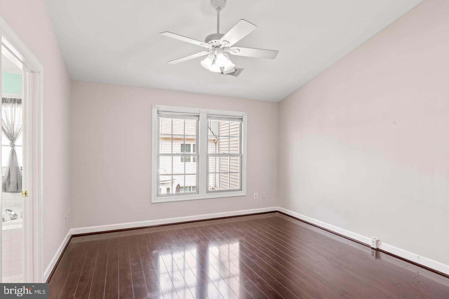 19893 Upland Terrace Ashburn, VA 20147 - Photo 21 of 29 an empty room with wooden floor chandelier fan and windows