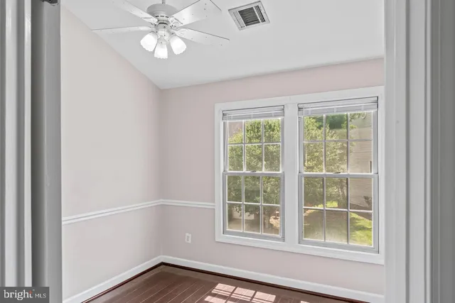 an empty room with a window and a fan