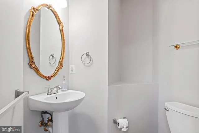 a bathroom with a sink a toilet and a mirror