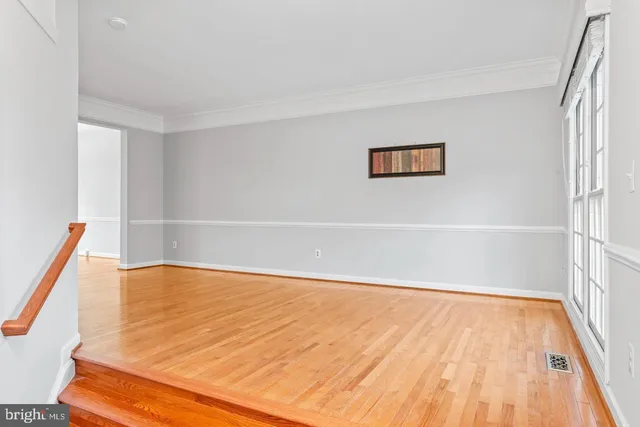 a view of a room with wooden floor and white walls