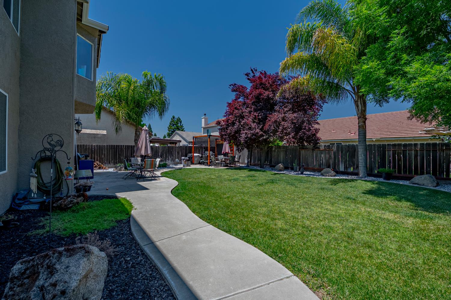 1833 La Quinta Court Merced, CA 95340 - Photo 52 of 55 a view of a patio with table and chairs potted plants and palm tree