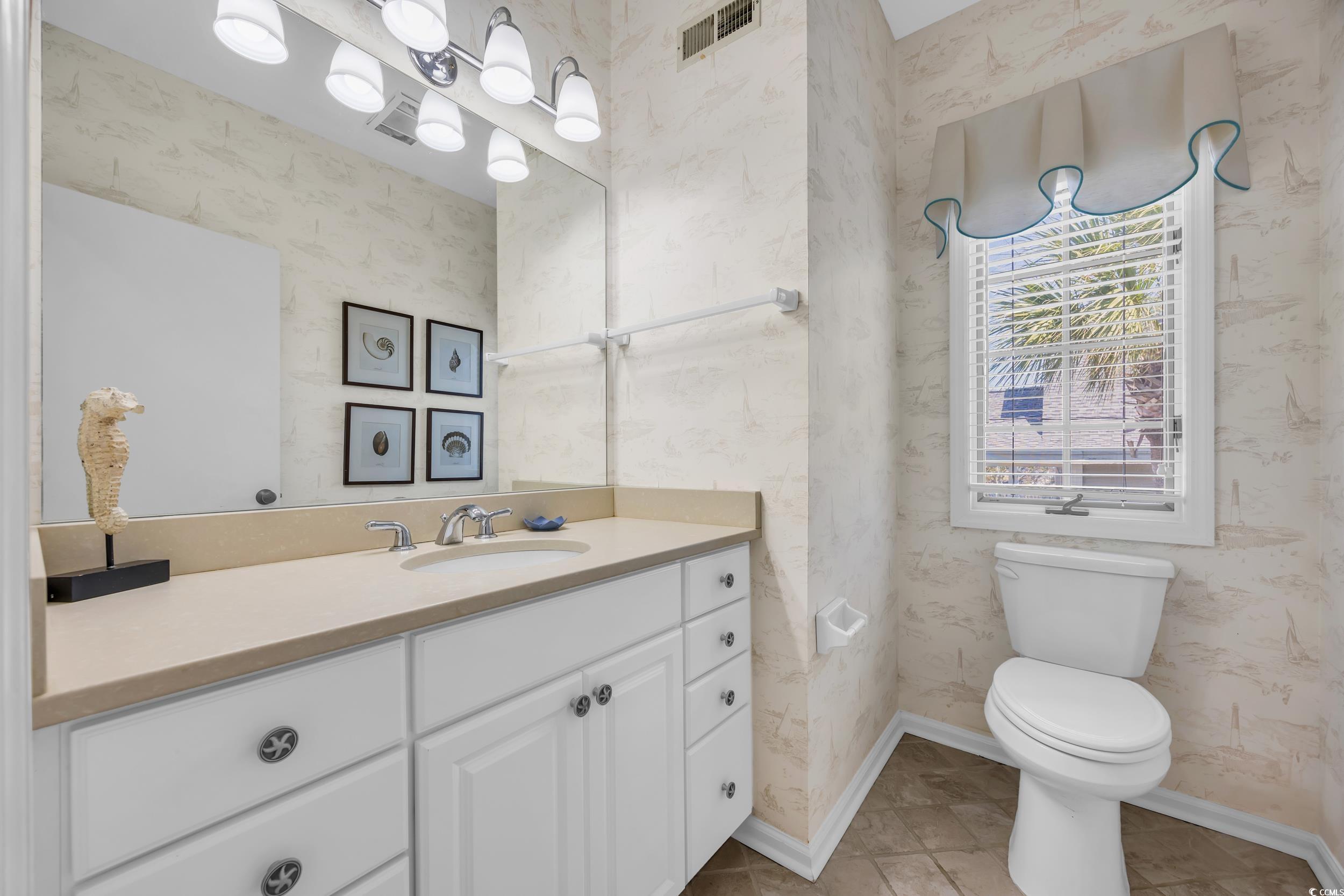 471 Norris Drive Pawleys Island, SC 29585 - Photo 22 of 40 Half bath with wallpapered walls, vanity, and light tile patterned flooring
