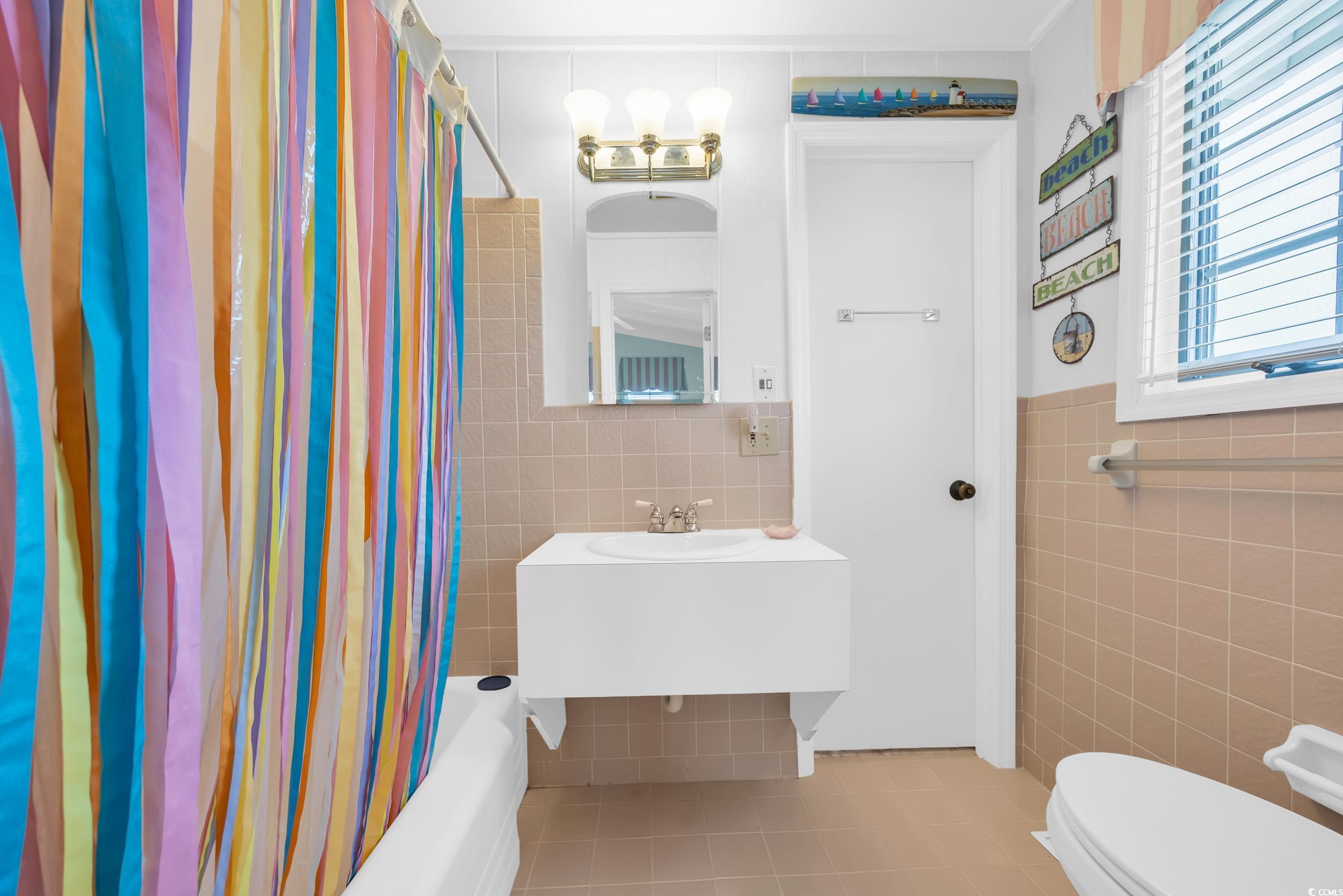 471 Norris Drive Pawleys Island, SC 29585 - Photo 25 of 40 Full bathroom featuring tile patterned flooring, tile walls, and shower / tub combo with curtain