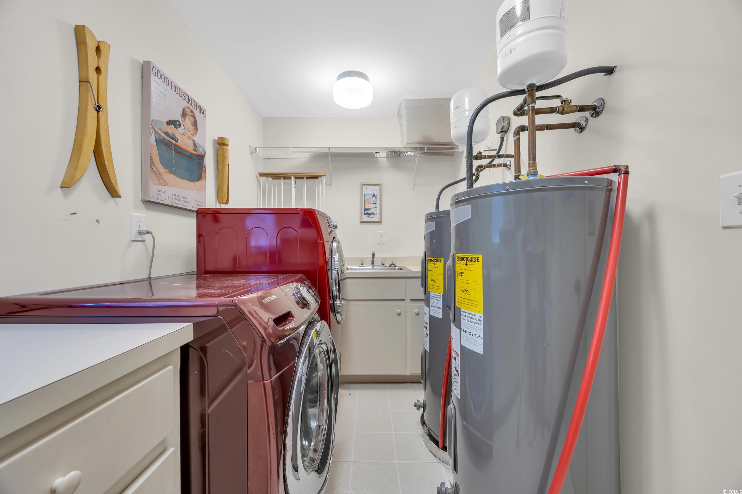 471 Norris Drive Pawleys Island, SC 29585 - Photo 35 of 40 Laundry area with electric water heater, washer and dryer, light tile patterned flooring, and cabinet space