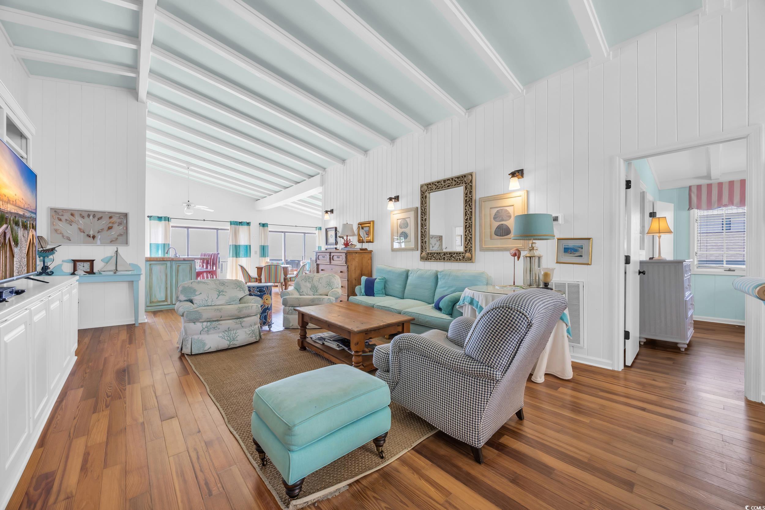 471 Norris Drive Pawleys Island, SC 29585 - Photo 8 of 40 Living room featuring dark wood-style flooring, wooden walls, and a ceiling fan