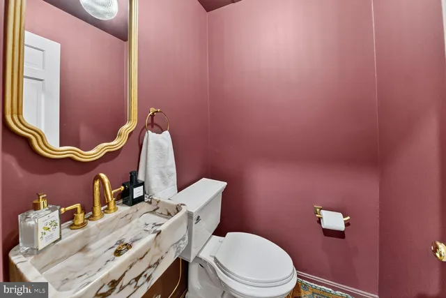 a bathroom with a sink mirror vanity and toilet