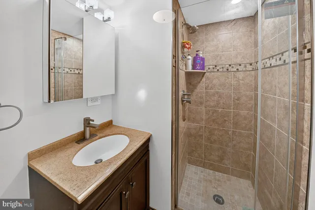 a bathroom with a sink shower and a mirror
