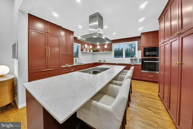 a kitchen with stainless steel appliances granite countertop a sink dishwasher and a refrigerator with wooden floor