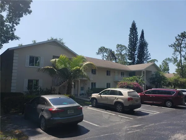 a front view of a house with cars parked