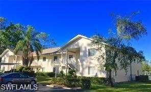240 Timber Lake Circle, Unit D202 Naples, FL 34104 - Photo 2 of 25 a front view of a house with a yard
