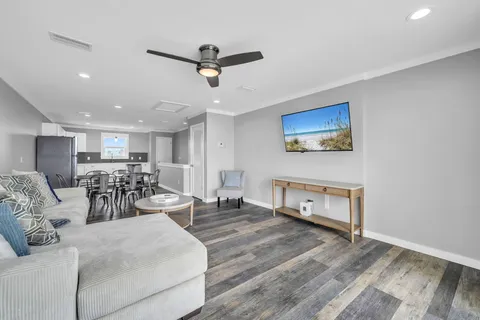 a kitchen with stainless steel appliances granite countertop a stove top oven a sink dishwasher a dining table and chairs with wooden floor