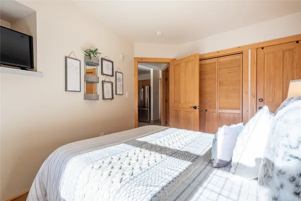 a bedroom with a large bed and a flat screen tv