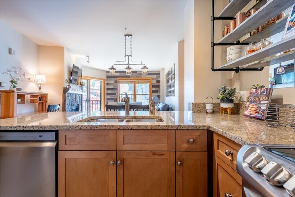 a kitchen with stainless steel appliances granite countertop a sink and a refrigerator