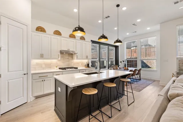 a kitchen with kitchen island a stove a table a sink and a refrigerator