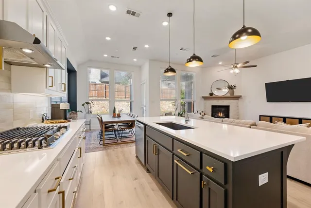 a kitchen that has a lot of cabinets in it and wooden floors