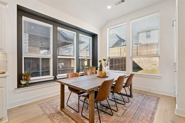 a view of a dining room with furniture large windows and wooden floor