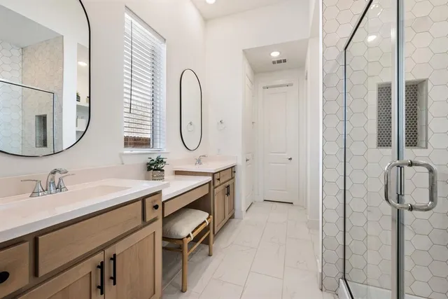a bathroom with a double vanity sink a mirror and a shower