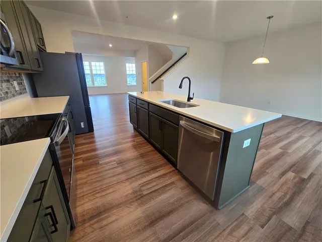 a kitchen with a sink and wooden floor
