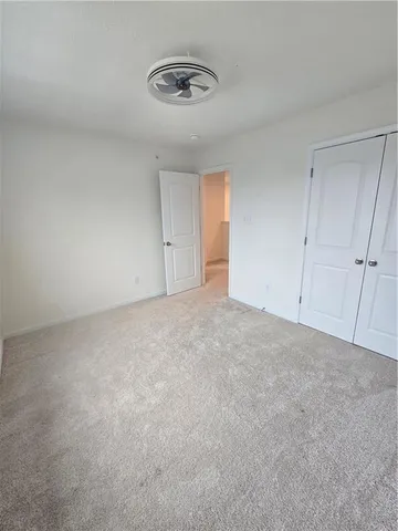 a view of an empty room and a ceiling fan