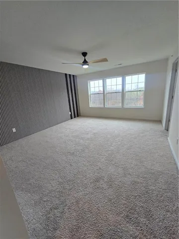 en empty room with windows and ceiling fan