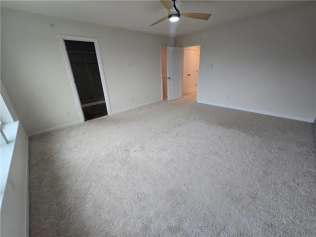 an empty room with a empty space and a ceiling fan