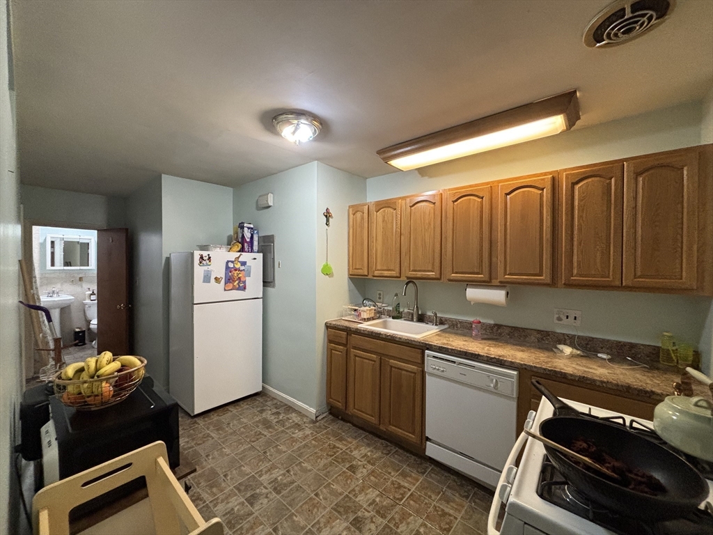 54 Tudor Street, Unit 1 Lynn, MA 01902 - Photo 3 of 10 a kitchen that has a sink stove and cabinets