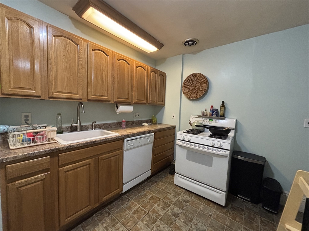 54 Tudor Street, Unit 1 Lynn, MA 01902 - Photo 4 of 10 a kitchen with sink cabinets and stove