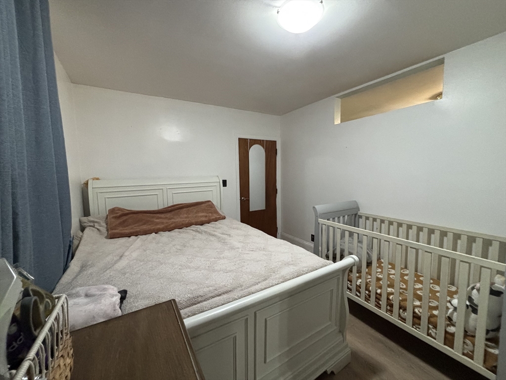 54 Tudor Street, Unit 1 Lynn, MA 01902 - Photo 8 of 10 a bedroom with a bed and wooden floor