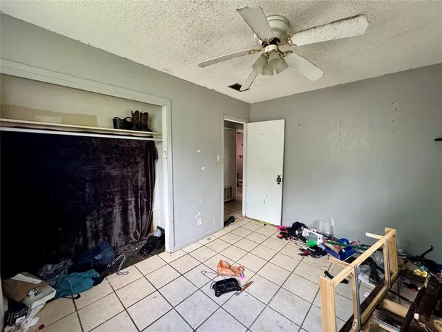 a bedroom with a bed and a chandelier fan