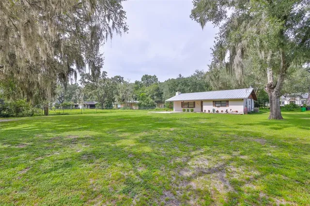 a front view of a house with garden and trees