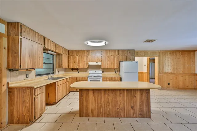 a kitchen with a sink a stove cabinets and counter space