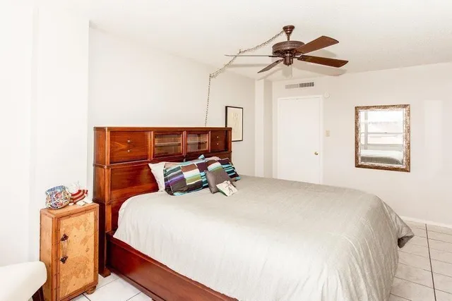 a bedroom with a bed and a chandelier fan