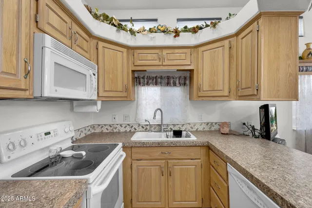 a kitchen with a sink cabinets and living room view