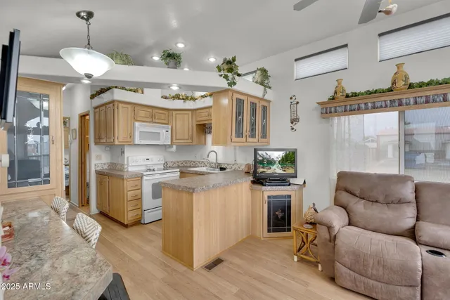 a living room with furniture kitchen view and a chandelier